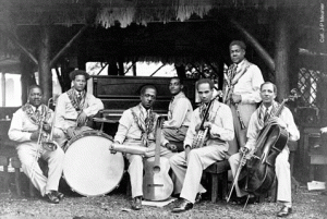 La orquesta de Stellio en la exposición internacional de 1931.  Masséna (tb), Marcel Lémon (dm), Paul Mathias (g, chacha), Gaston Adélaïde (p), Henri Boye (bjo), Stellio (cl), Duverger (viol). Foto de la colección de J.P. Mounier. Extraída de esta web.